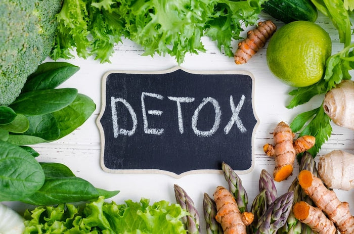 Détox printanière avec aliments verts, racines de curcuma frais et tableau “detox” illustrant le soutien naturel du foie
